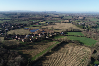 Green landscape vista with fields and hedges, taken from a drone in the sky