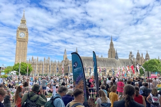 A large crowd in front of the Houses of Parliament and Big Ben, some holding blue Shropshire Wildlife Trust banners