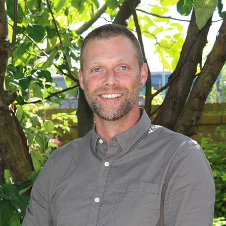 Headshot of man in front of a tree