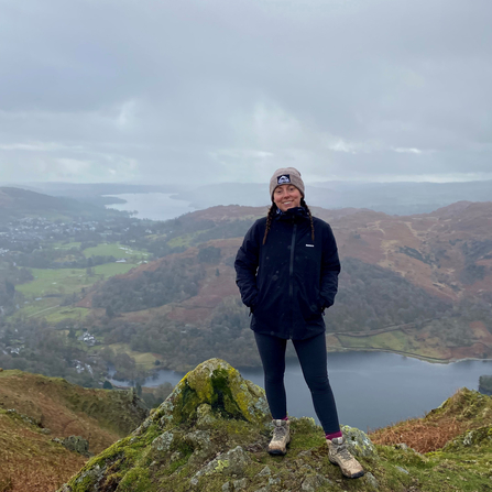 Young woman stood on mountain above a lake